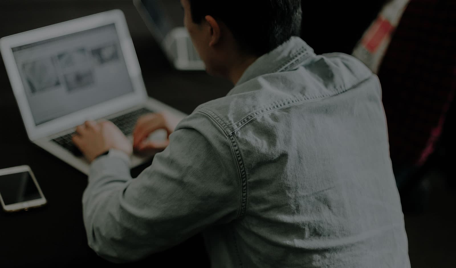 A person working on a laptop at a desk