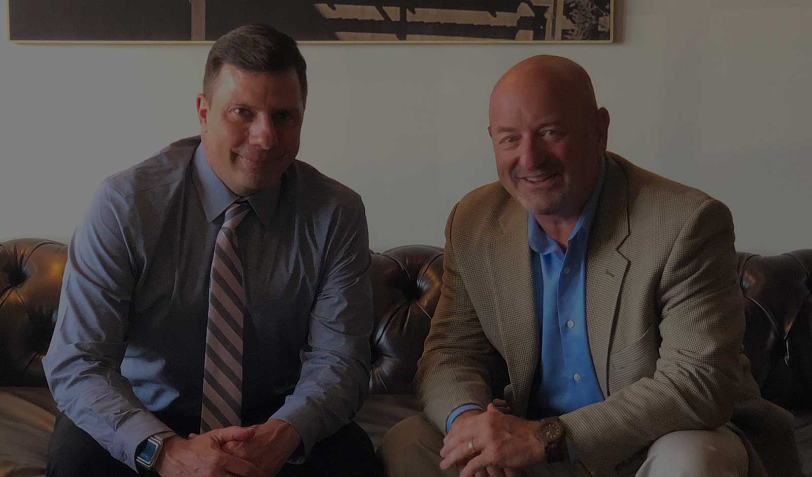 An image of Dennis Franczak and John Cimperman sitting on a couch