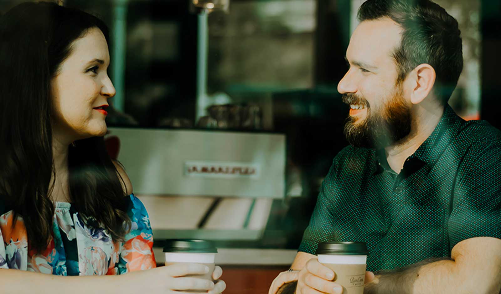 A man and a woman talking over coffee.