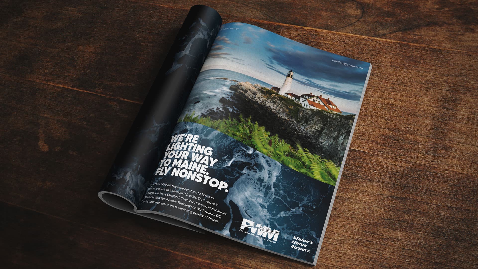 A magazine on a table showing an ad with a lighthouse.