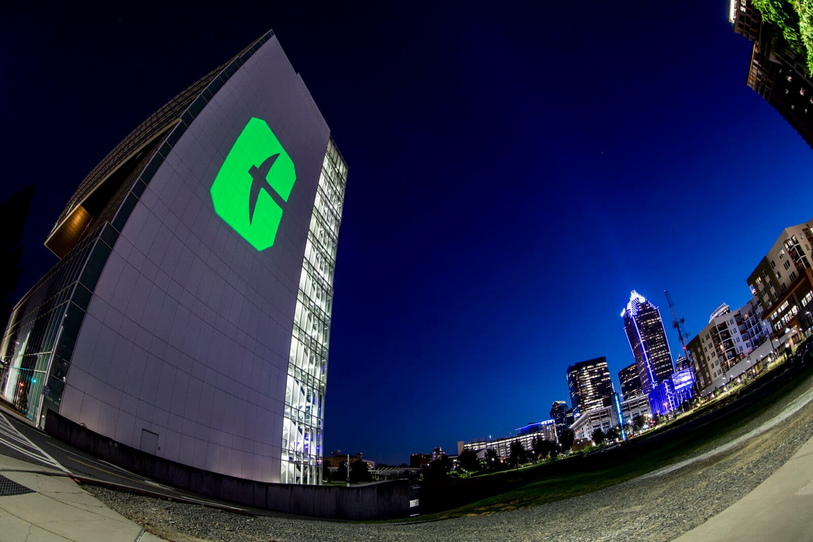 At night, the UNC Charlotte Logo is projected on a tall building on campus.