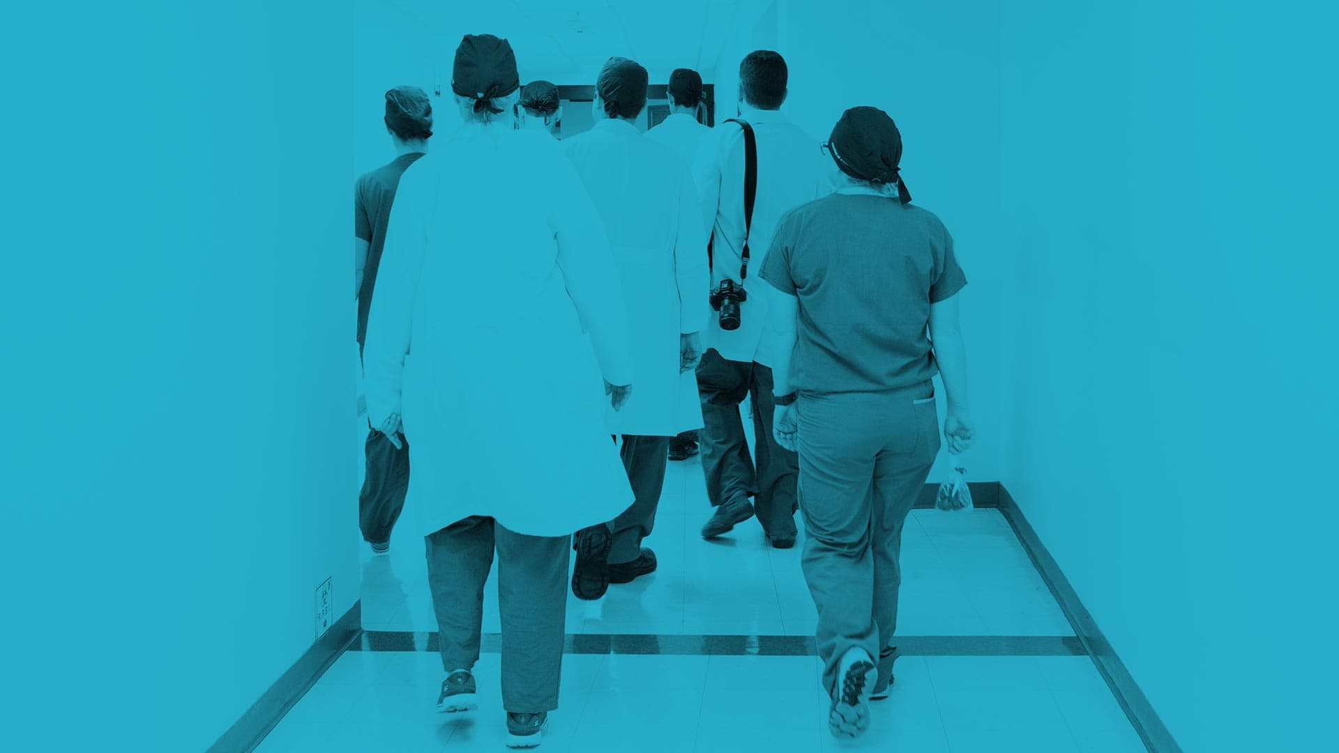 Doctors and medical staff walking down a hospital hallway.