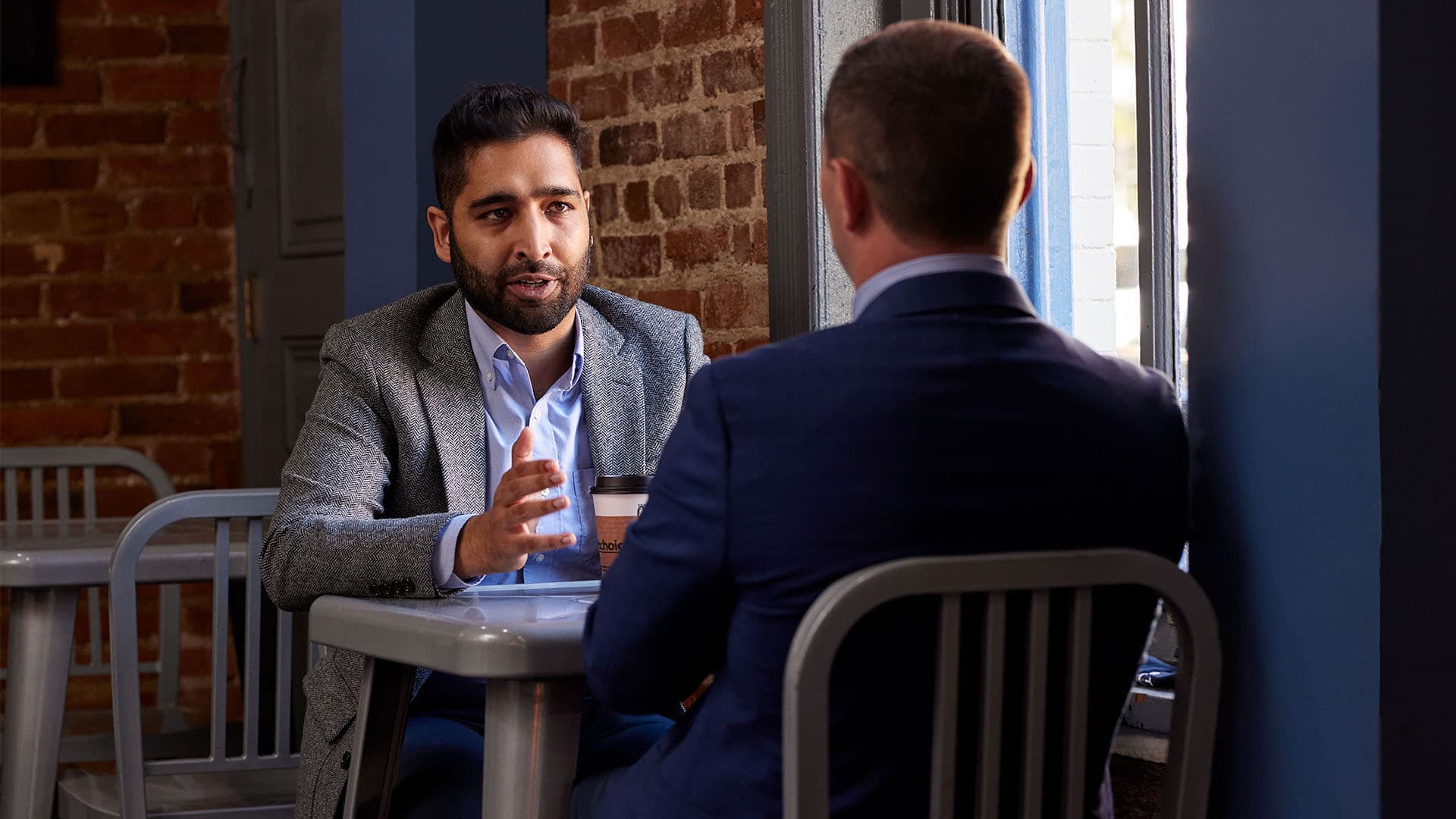 Two people sit at a table having a discussion