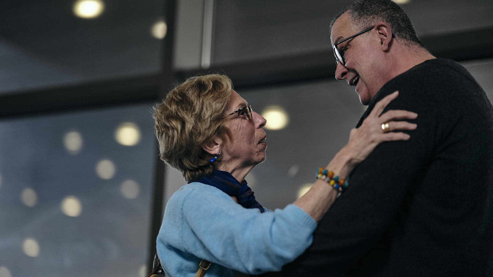 A couple embraces after reuniting in the airport.