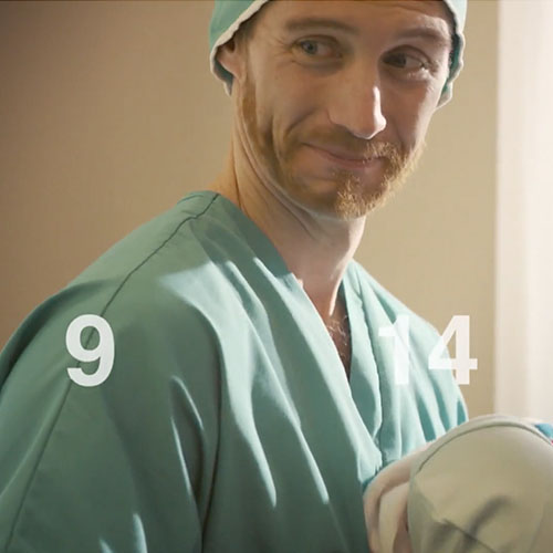 Man holding his new baby with his indelible numbers appearing around him