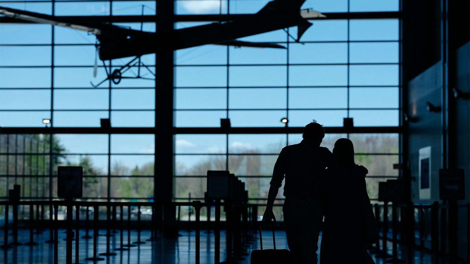 A couple walks towards security at the airport